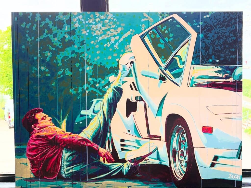 Colorful mural of a man on the ground reaching toward a white van with a damaged front end.