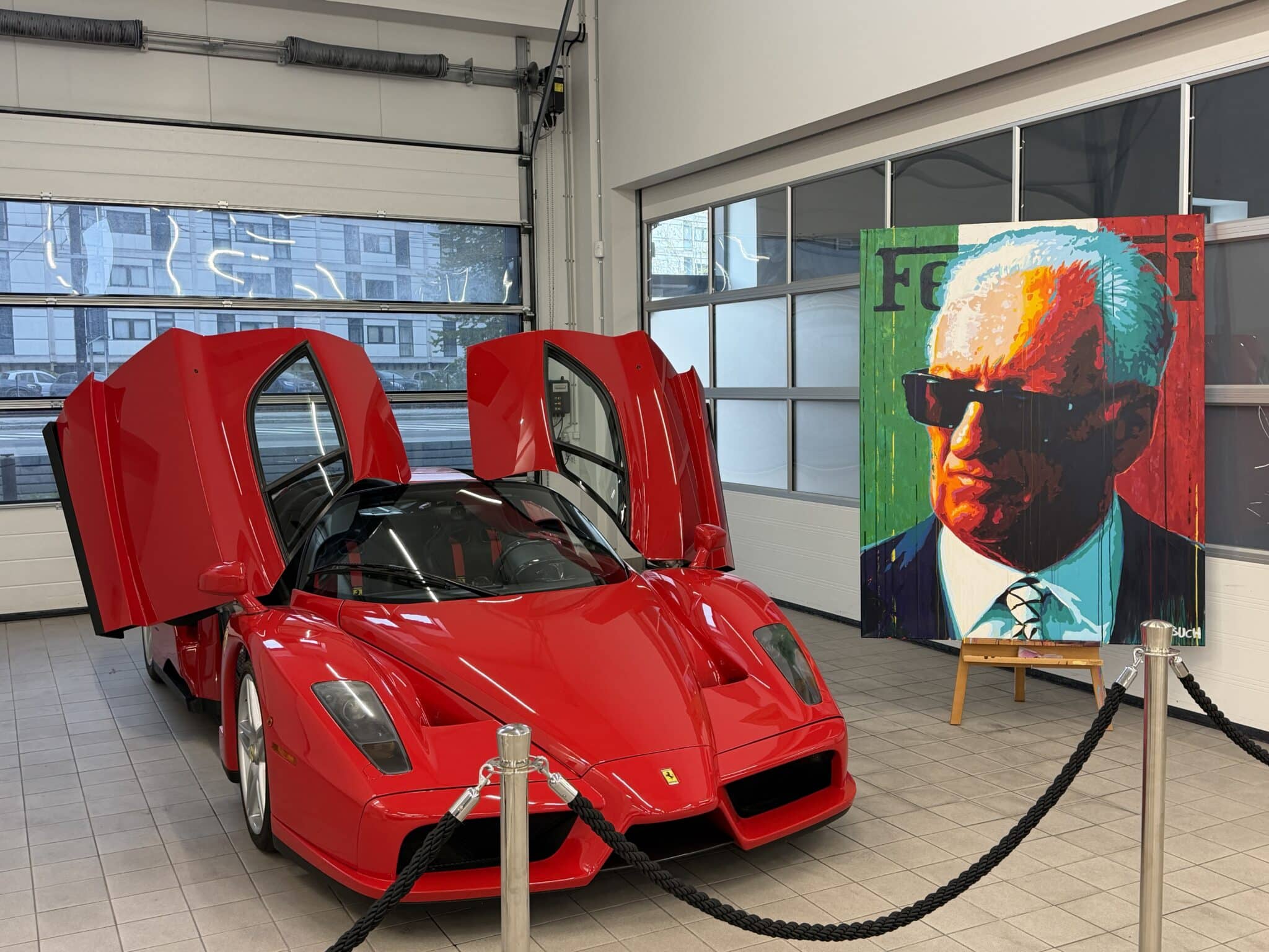 Enzo Ferrari painting together with a red Ferrari Enzo